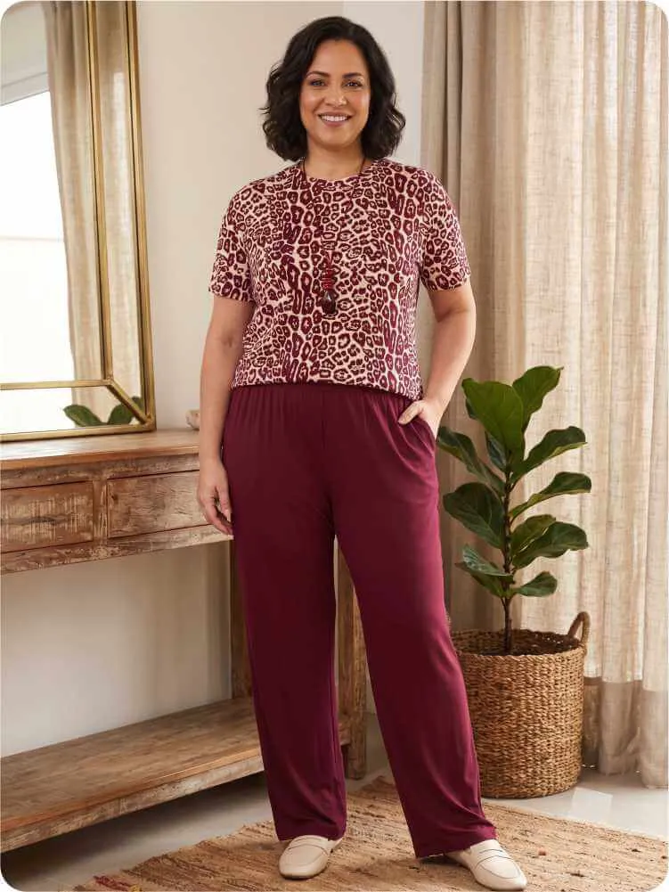 Mulher aprendendo como usar calça pantalona vinho com blusa de malha estampada Mariantônia.